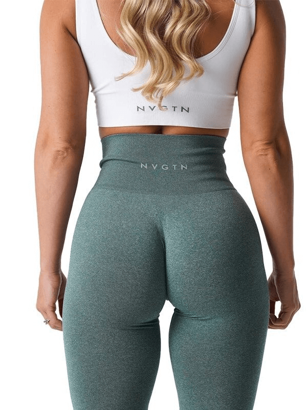 Back view of a woman wearing tight teal sports leggings and a white sports bra, showcasing the fit and elastic waistband.